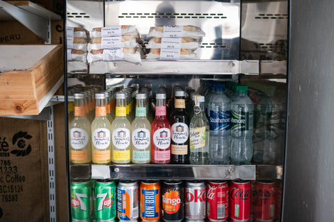 display of soft chilled drinks in a fridge served at the Real Food Cafe in tyndrum including water, lemonade and internationally recognised soda cans