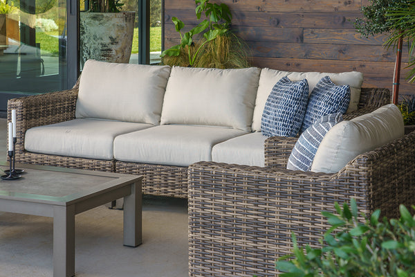 Outdoor sofa and chair on patio with blue pillows