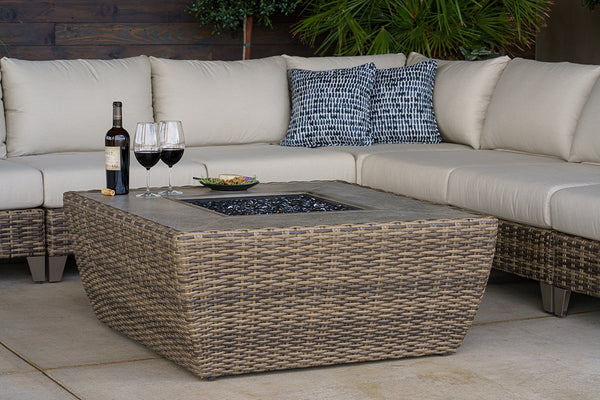 Wicker Fire Pit with Glass Beads in the center of a sectional sofa