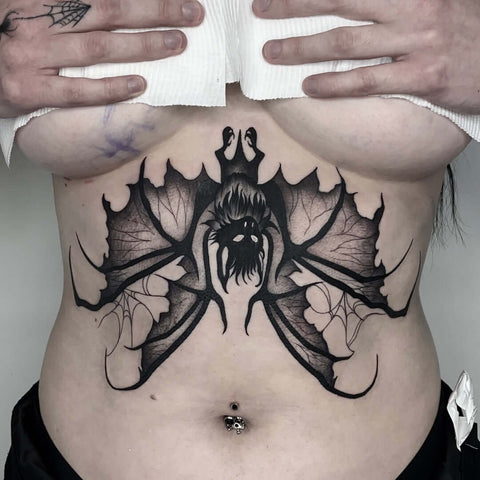 a spooky bat tattoo on the sternum