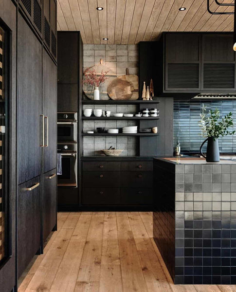 une cuisine noir parquet bois doré avec ilot bar en  mosaïque noir brillant.