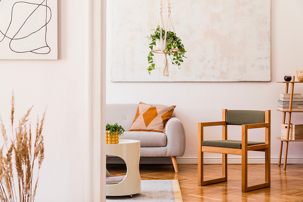 Salon minimaliste avec art moderne, plantes et mobilier en bois.