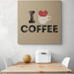 Tableau cuisine deco beige avec une illustration d'un cœur rouge qui déborde d'une tasse de café et une inscription en noir i love café, accroché sur un mur blanc