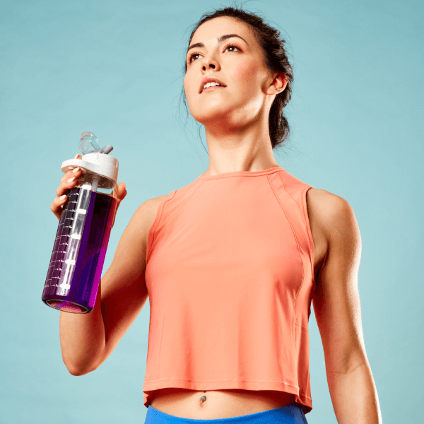 A fit woman in athletic wear holding a water bottle, gazing ahead with determination, embodying an active lifestyle and hydration post-workout, set against a soft blue background