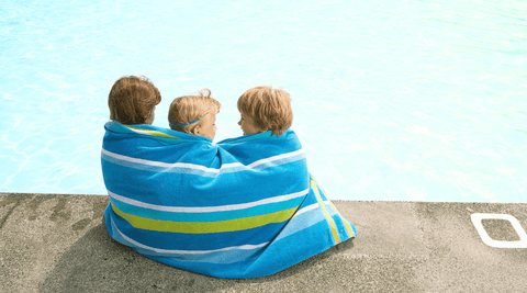 trois enfants sur la page entoures dune serviette de plage