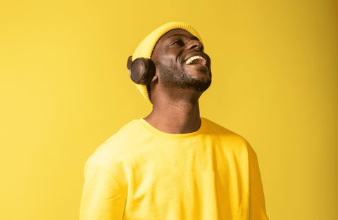 homme habille en jaune ecoutant de la musique avec un casque audio