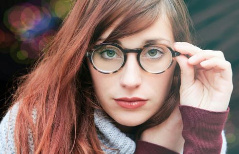 Une femme fixe l'objectif avec ses lunettes