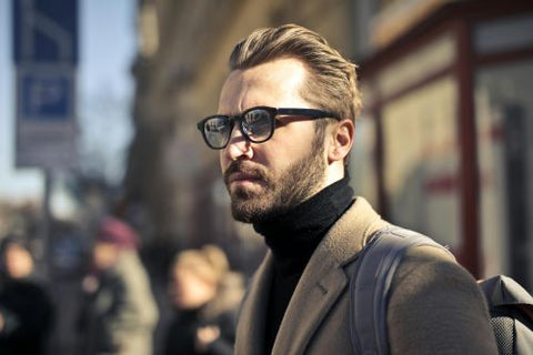 Un homme regarde au loin car il a vu quelque chose d'intriguant grâce à ses lunettes