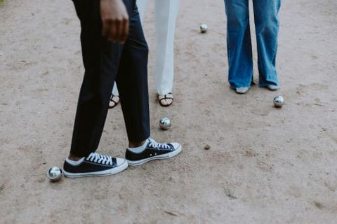 Un homme a les pieds tanqués dans la partie de pétanque