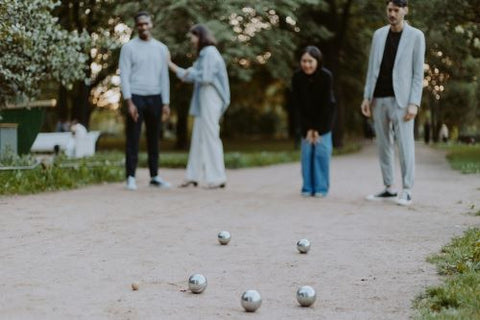 4 personnes jouent à la pétanque et se demandent "tu tires ou tu pointes ?!"