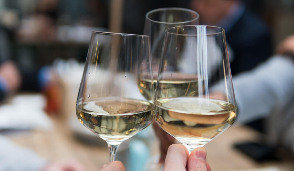Drei Personen die mit Ihren Gläsern mit alkoholfreiem Wein anstoßen