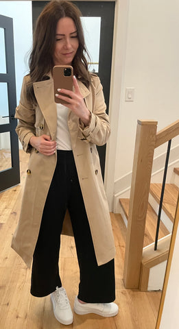 women wearing trench coat with white sneakers and black wide leg pants