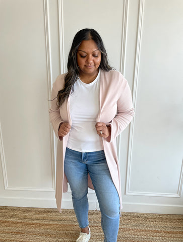 indian woman standing wearing a blush pink cardigan and a white bamboo crewneck t-shirt and light wash denim jeans