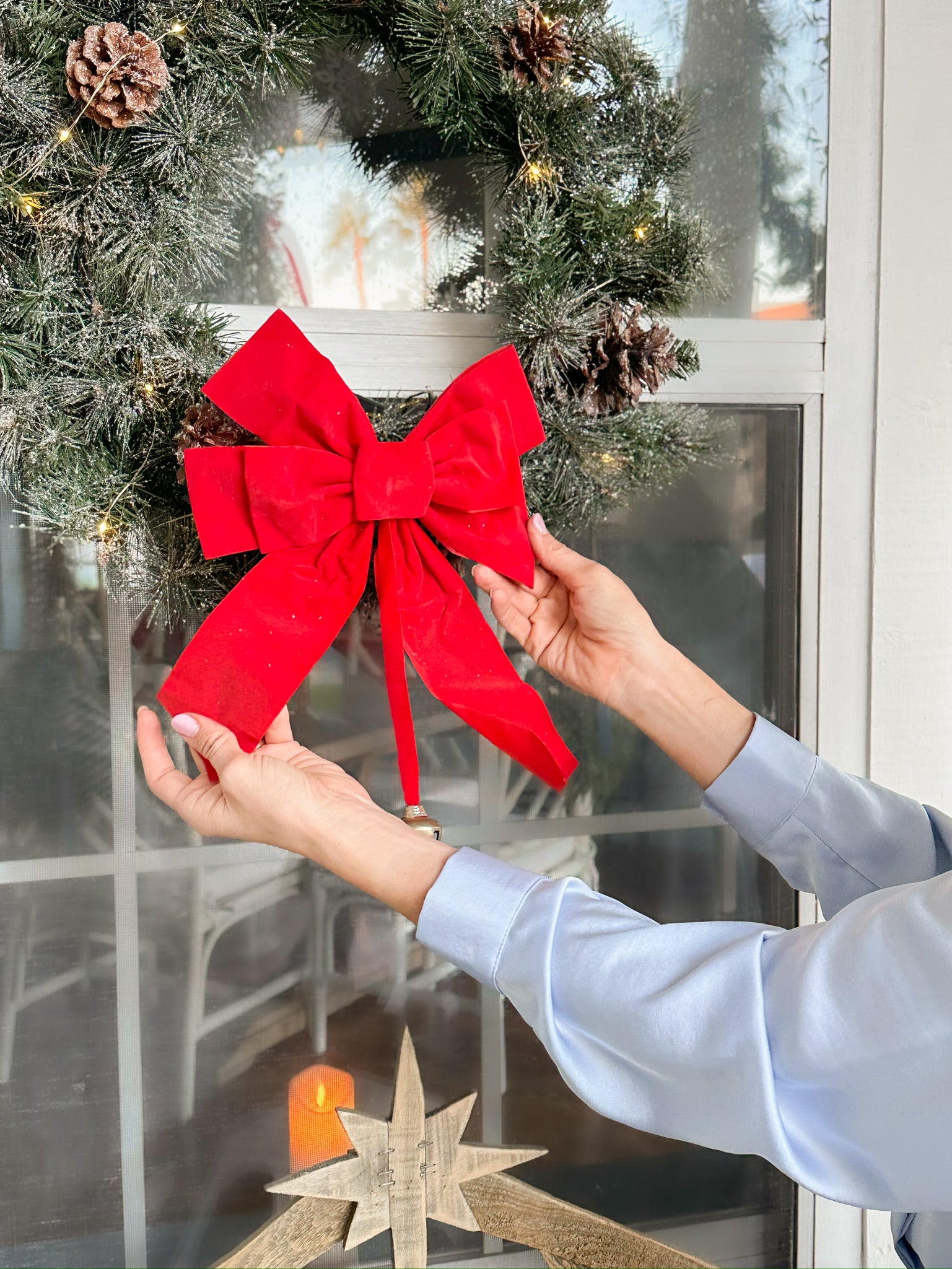Placing a Bow on a Christmas Wreath