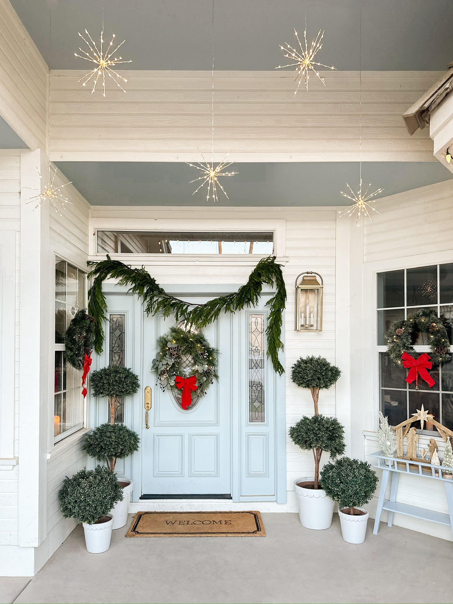 Front Door Showcasing Hanging Lights and the Garland
