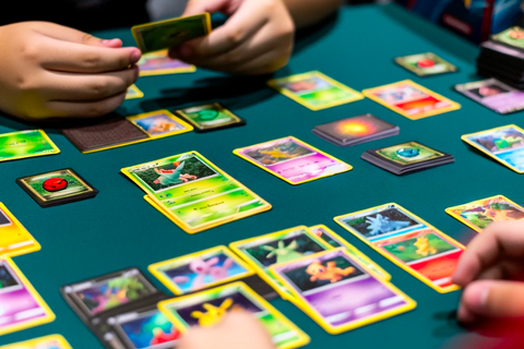 Un gros plan sur des mains mélangeant un deck de cartes Pokémon colorées, préparant le jeu