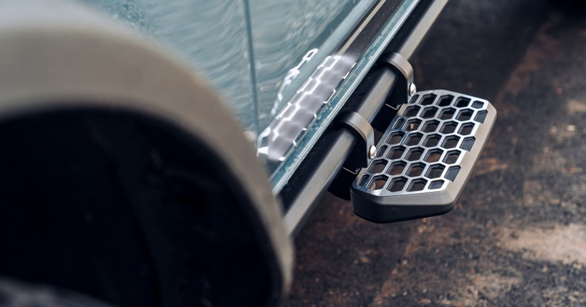 a close up of archetype racing's side step/magnum stirrup is attached to the driver side of a ford bronco