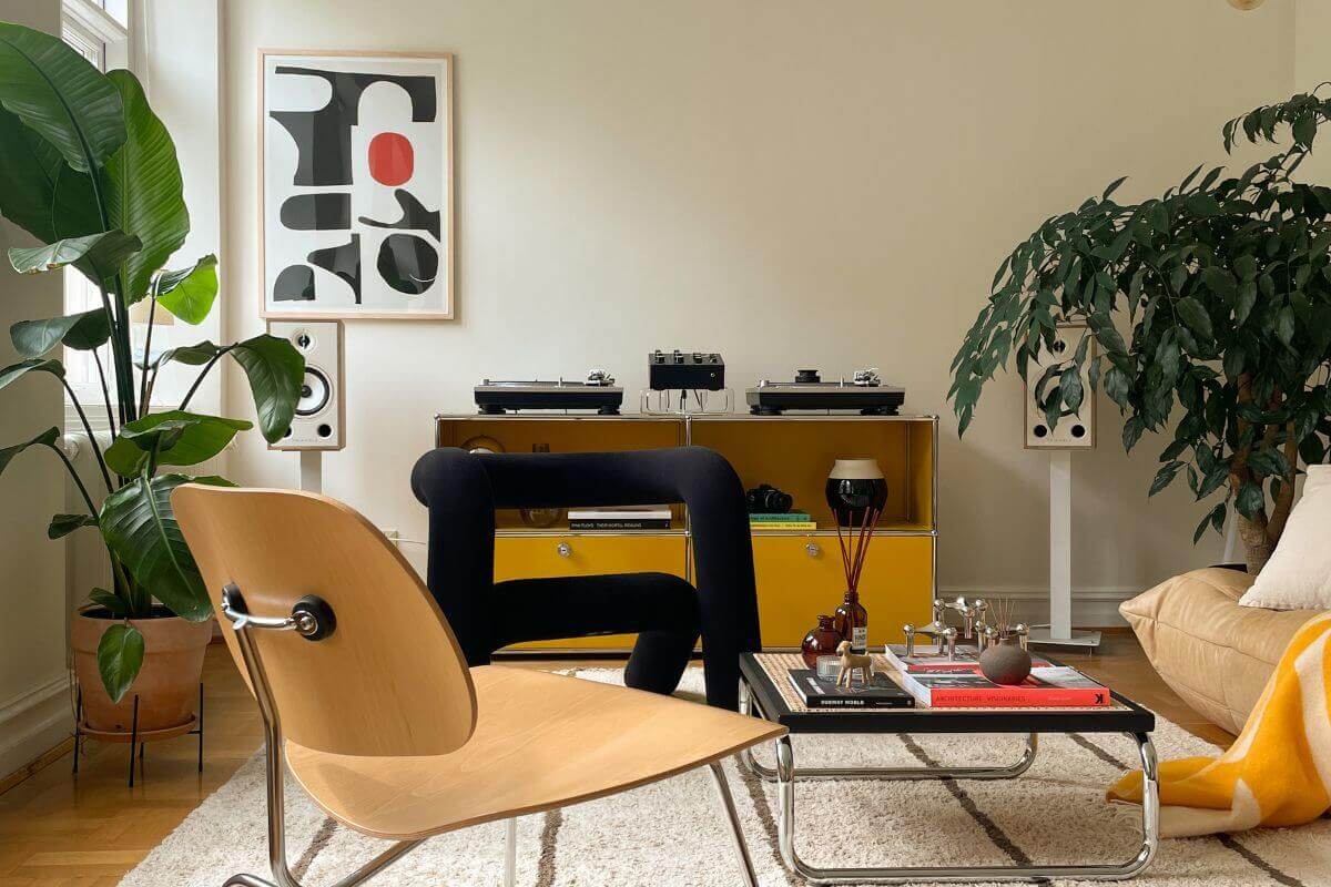 living room with yellow hues, an accent black chair and a framed artwork hung on the wall