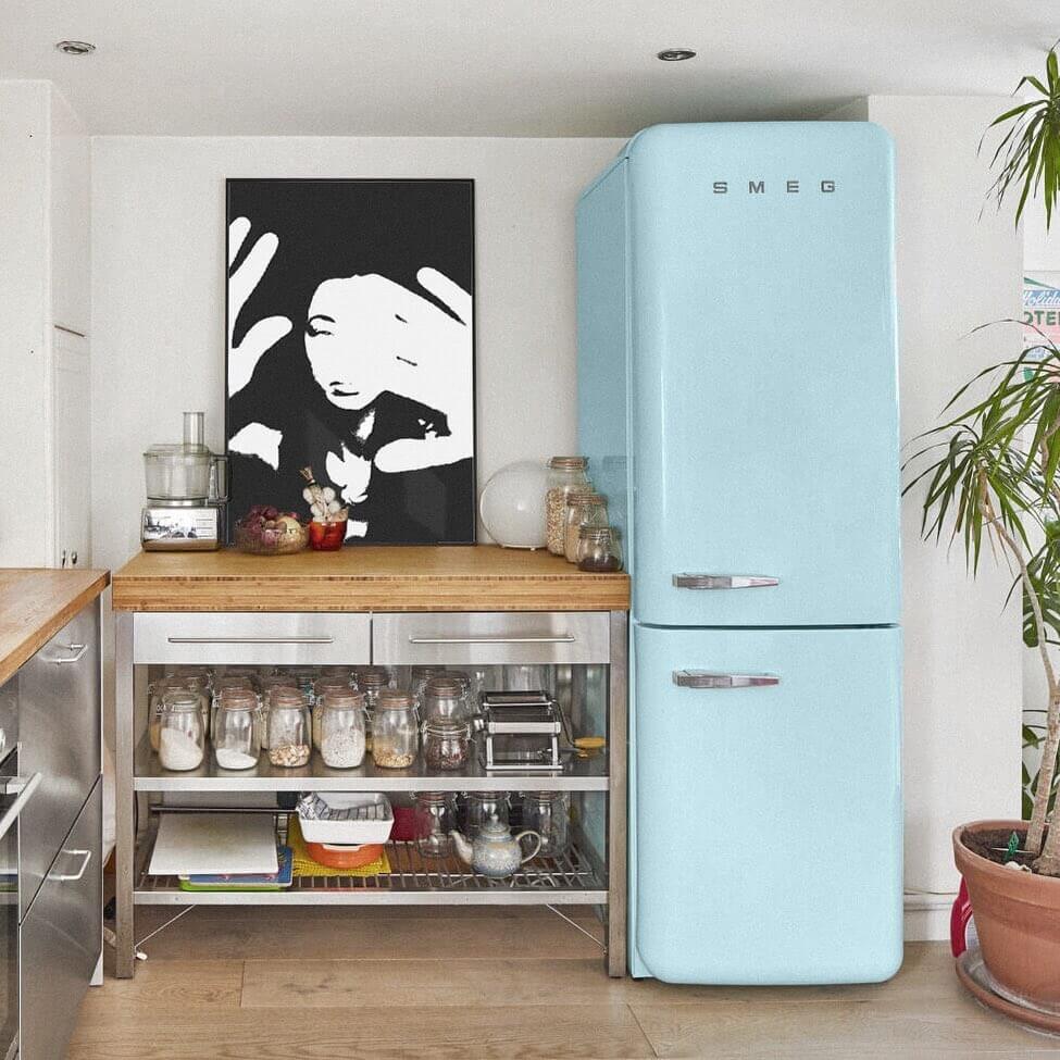 modern Kitchen With A Blue Fridge And Black And White Artwork On The Counter Top Leant Against The Wall