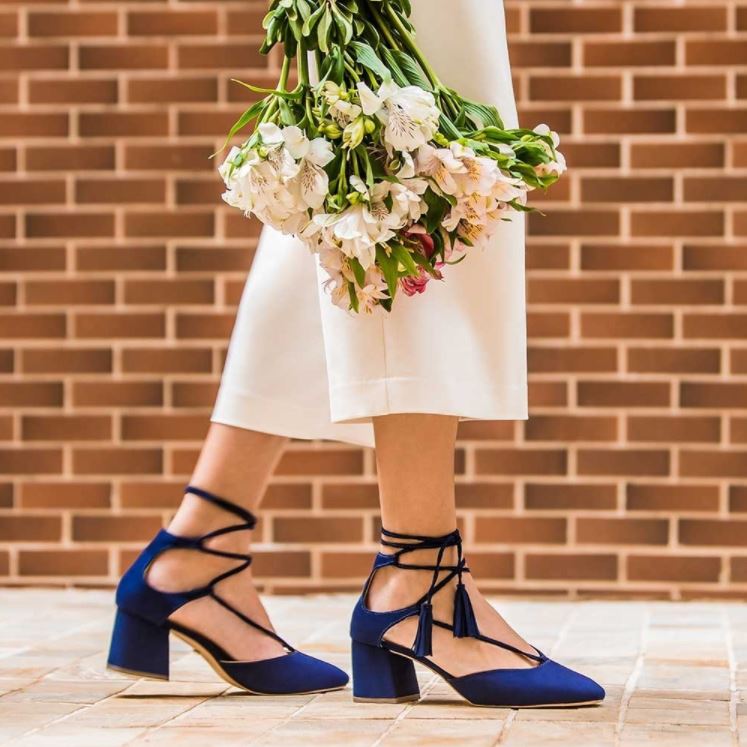 Foto de modelo calçando scarpin azul e calça pantacourt nude.