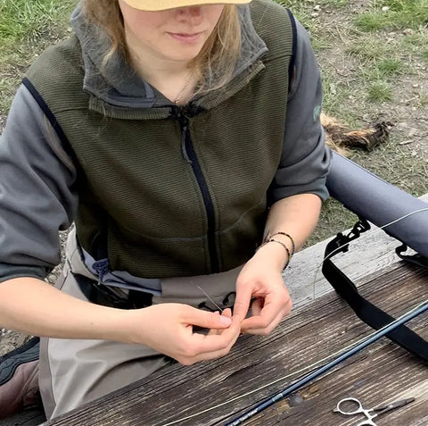 Fly fisher ties tippet onto a nymphing rig.