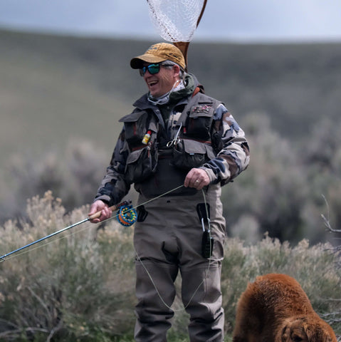Fly fisherman laughs while stripping in his fly line.