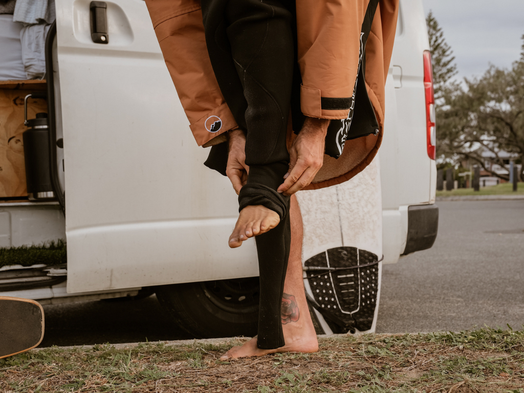 Get Rug'd HydroCloak Ultimate Changing Robe and alternative to Hooded Towel Poncho. Man getting changed in changing robe into wetsuit in front of a camper van