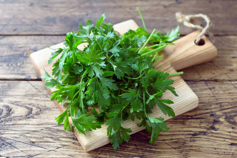 bouquet-de-persil-frais-biologique-sur-une-planche-a-découper-sur-une-table-en-bois