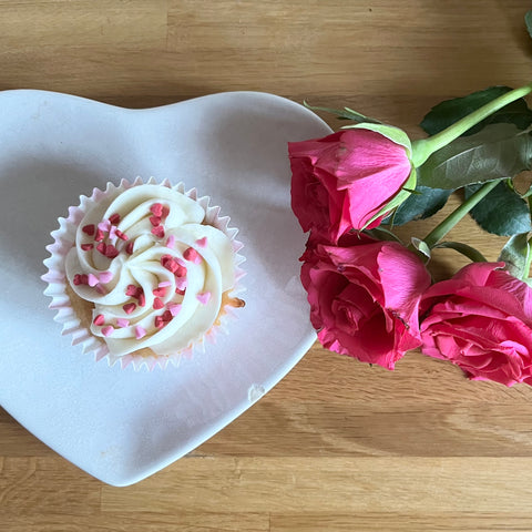 Valentines cupcake on a plate with some pink roses
