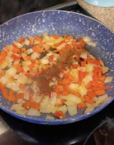 Once cooked down, add garlic, cayenne, smoked paprika, and chili powder. Cook for about a minute.