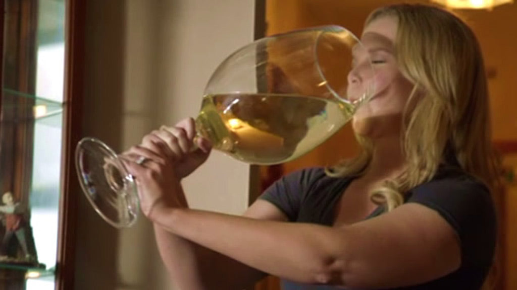 Amy Schumer drinking a large glass of wine