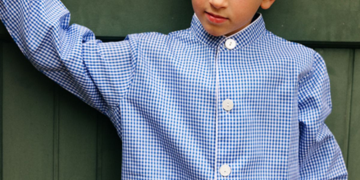 petit garçon qui porte un tablier bleu à carreaux blanc