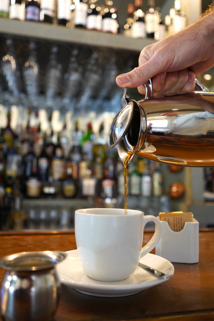 Fresh coffee being poured into a white mug