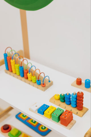 giocattoli colorati in legno esposti su uno scaffale