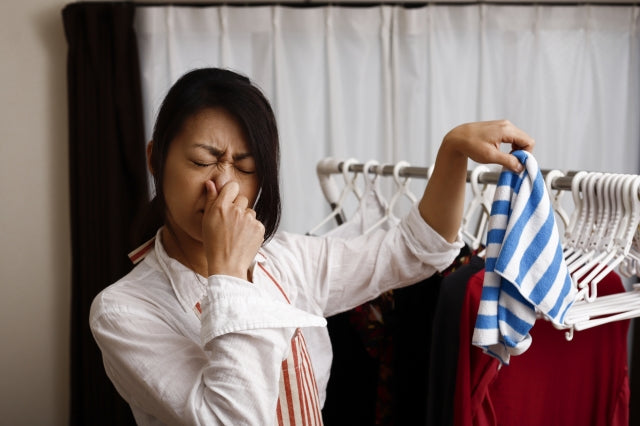 臭くて鼻をつまむ女性