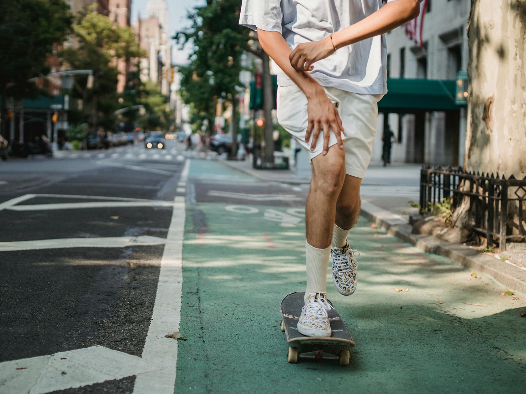 Person skateboarding in a bike lane on a city street.