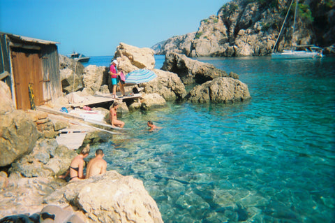 People sitting on the rocks by the ocean in Ibiza taken on Kodak Gold 200 35mm Film