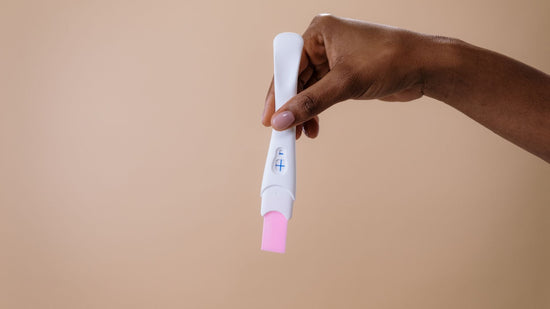 donna con in mano un test di gravidanza positivo