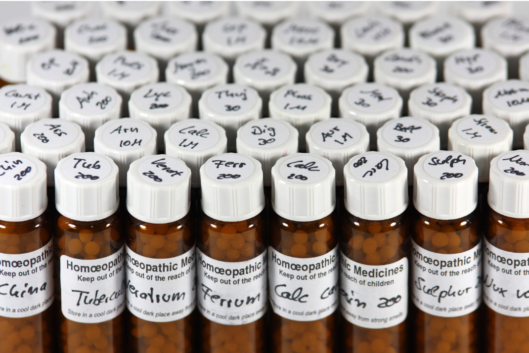 small brown bottles of homeopathic pillule remedies with white lids and labels.