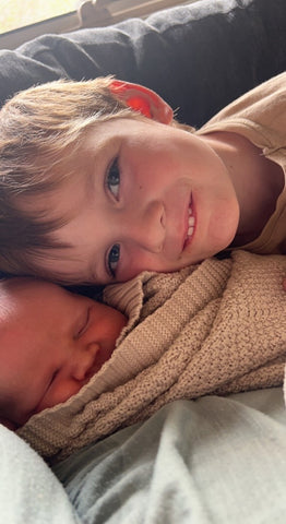 Two Brothers snuggled on a couch 