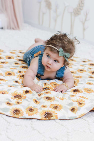 Baby girl nursery with a Snuggly Jacks Sunflowers Playmat on the ground. 