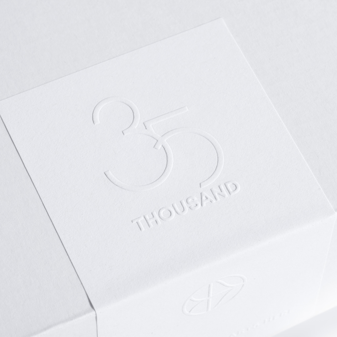35 Thousand white box packaging with logo embossed on top of white sticker 