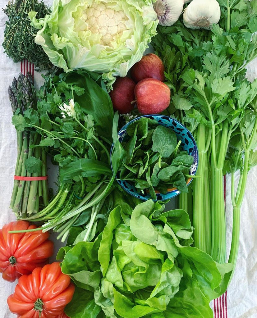 A flatlay of a variety of vegetables, cauliflower, lettuce, tomatoes, garlic, parsley, 