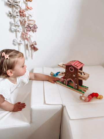 Toddler playing with Pixie Dust Tree House train toy