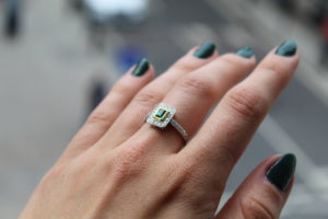 emerald and diamond ring on a hand reaching out to hatton garden london