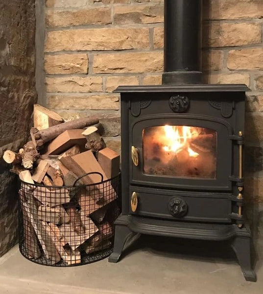 Lit woodburning stove with a basket of wood