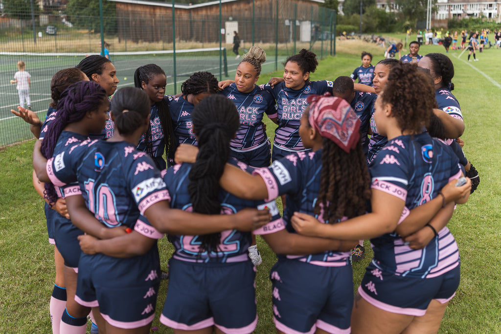 Black Girls Ruck team in embrace wearing Kappa kit