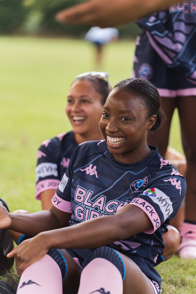 Black Girls Ruck players laughing wearing Kappa kit