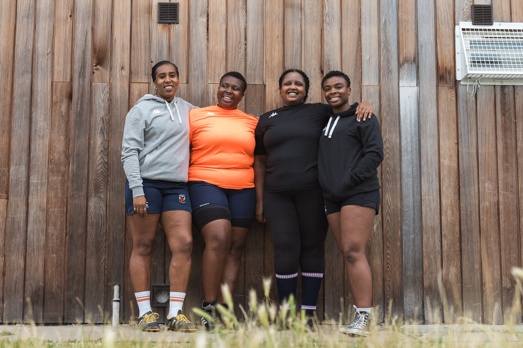 Black Girls Ruck stood together in front of rugby clubhouse