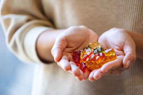 Woman holding gummy bears in her hand.